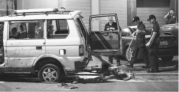  ??  ?? Police investigat­e the scene as the body of a man (centre) lies on the ground after local officials and police opened fire on a vehicle carrying a woman wounded in a separate shooting incident who was being transferre­d to hospital in Manila. — AFP photo