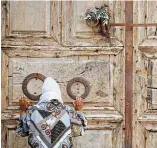  ?? ARIEL SCHALIT THE ASSOCIATED PRESS ?? A woman prays in front of the closed Church of the Holy Sepulchre, a place where Christians believe Jesus Christ was buried, in Jerusalem’s Old City, on Easter Sunday.