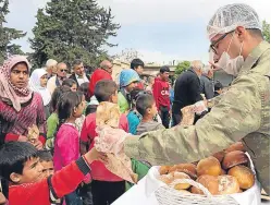  ?? Getty. Picture: ?? A Turkish soldier delivers bread to citizens of Jindires town in Syria.