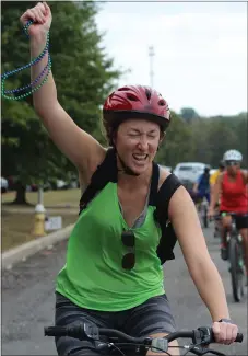  ?? PHOTO BY MICHILEA PATTERSON – FOR MEDIANEWS GROUP ?? A woman holds beads in her hand and smiles as she finishes the 2019 Ride for the River event.