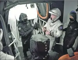  ?? SpaceX ?? NASA astronauts Bob Behnken, foreground left, and Doug Hurley talk with technician­s after leaving the Crew Dragon capsule Wednesday in Cape Canaveral, Fla.