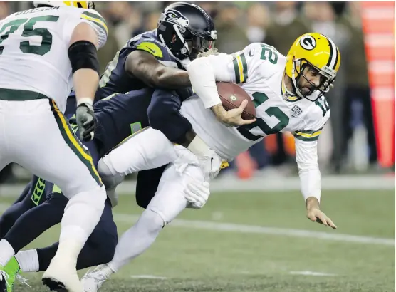  ?? STEPHEN BRASHEAR/THE ASSOCIATED PRESS ?? Green Bay Packers quarterbac­k Aaron Rodgers is sacked by Quinton Jefferson during first-half NFL action on Thursday in Seattle.