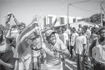  ?? Marco Longari AFP/Getty Images ?? GAMBIANS CELEBRATE the victory of opposition leader Adama Barrow over Yahya Jammeh in the tiny nation’s presidenti­al election, the latest sign of West Africa’s emergence as a democratic stronghold.