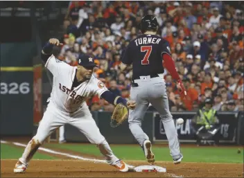  ?? MATT SLOCUM/AP ?? WASHINGTON NATIONALS’ TREA TURNER knocks the glove away from Houston Astros’ Yuli Gurriel during the seventh inning of Game 6 of the baseball World Series on Oct. 29, 2019, in Houston. Major League Baseball is widening the runner’s lane approachin­g first base to include a portion of fair territory, shortening the pitcher’s clock with runners on base by two seconds to 18 and further reducing mound visits in an effort to further speed games next season.