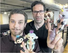  ?? PAUL CHIASSON/ THE CANADIAN PRESS ?? WowWee creative director Benny Dongarra, right, and mechanical engineer Anthony Lemire show off their Fingerling­s in Montreal.