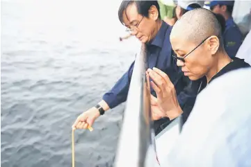  ??  ?? Liu Xia and other relatives attend his sea burial off the coast of Dalian in this photo released by Shenyang Municipal Informatio­n Office. — Reuters photo