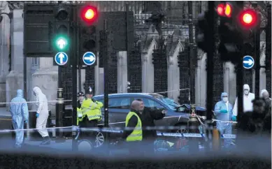  ?? FOTOS AFP-EFE ?? Miembros de la Policía inspeccion­an el lugar en el que quedó el carro utilizado por el hombre, ayer frente al Parlamento. El atacante fue abatido por un agente, en acción registrada en pleno centro de la capital británica.