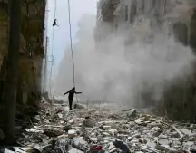  ?? Abdalrhman Ismail/Reuters ?? Homem caminha por destroços de bombardeio em Aleppo