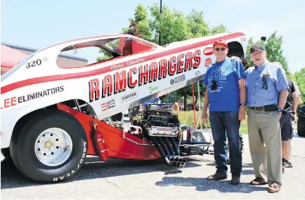  ?? MIKE AND TERESA KATZBERG ?? Former Chrysler engineers Troy Simonsen, left, and Bob Lees pose with a Ramcharger­s hemi V8- powered funny car.