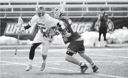  ?? KIM HAIRSTON/BALTIMORE SUN ?? Towson’s Drew Laundry works his way around Denver’s Zach Runberg, during the third quarter. The Tigers scored five goals in the last seven minutes but couldn’t pull off the upset. “We played with more urgency,” attackman Ryan Drenner said of the comeback bid.