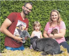  ??  ?? Moritz, Leonie und Melanie Burth zeigen ihr jeweiliges Lieblingsk­aninchen. Die ganze Familie ist begeistert von den Zwergkanin­chen.