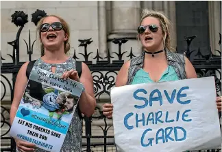  ?? GETTY IMAGES ?? Supporters of Chris Gard and Connie Yates, the parents of terminally ill baby Charlie Gard, protest outside the High Court in London during a hearing to decide whether he should receive further treatment. A member of the medical team that helped to...