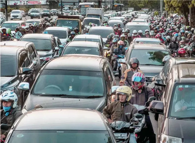  ?? Foto: AFP/Bay Ismoyo ?? Zwischen den stehenden Autos drängeln sich abertausen­de Mopeds – so sieht der tägliche Weg zur Arbeit für viele Indonesier aus.