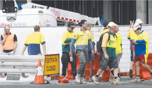  ?? Picture: TERTIUS PICKARD ?? Workers leave the Jewel constructi­on site in Surfers Paradise yesterday after a near tragedy involving three co-workers.