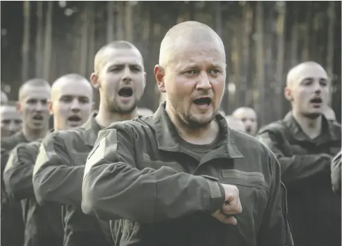  ?? EFREM LUKATSKY / THE ASSOCIATED PRESS FILES ?? Newly recruited soldiers celebrate the end of their training at a military base near Kyiv last year. Ukraine
has lowered the military conscripti­on age from 27 to 25 in an effort to replenish its depleted ranks.