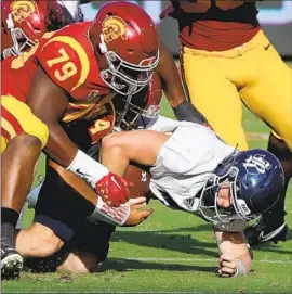  ?? Luis Sinco Los Angeles Times ?? DE’JON BENTON (79) leads a group of Trojans in bringing down quarterbac­k TJ McMahon during USC’s rout of Rice. The defense also had four intercepti­ons.