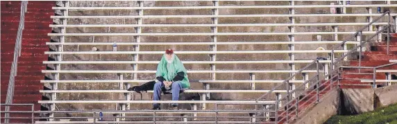  ??  ?? November: Journal photograph­er Roberto E. Rosales finds a lonely fan who decided to ride out the weather delay when the Lobo football team beat Nevada.