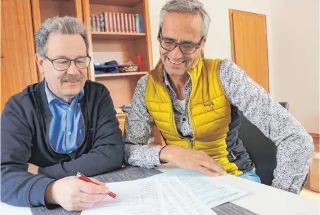  ?? FOTO: SEBASTIAN KORINTH ?? Pfarrer Wolfgang Drescher (links) und Pastoralre­ferent Matthias Kopp sehen sich die Ergebnisse der Umfrage an. In manchen Punkten üben die Gläubigen deutliche Kritik, andere geben durchaus Anlass zur Freude.