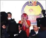  ?? AFP/STRINGER ?? MetroBank’s Vice President Maria Victoria Lopez (centre) hides her face during a press conference at the National Bureau of Investigat­ion headquarte­rs in Manila on Friday.