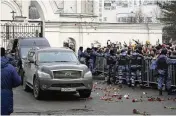  ?? ?? People throw flowers at the van carrying the coffin of Russian opposition leader Alexei Navalny Friday. Navalny, has been buried in Moscow, two weeks after his still-mysterious death in an Arctic prison.