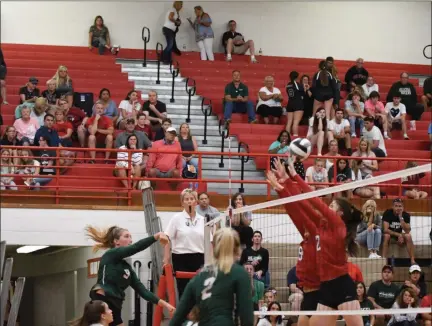  ?? PATRICK HOPKINS — FOR THE NEWS-HERALD ?? Lake Catholic’s Taylor Resetar, right, hits past Mentor’s Hannah Sanford and Caitlin Churney on Aug. 24.