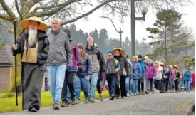  ?? AP PHOTO/STEVE BLOOM/THE OLYMPIAN ?? Koro Kaisan Miles, a Zen priest and resident teacher at Open Gate Zendo, leads a group of well over 100 people around Capitol Lake in Olympia, Wash., on Sunday during the 12th annual silent peace walk in honor of Dr. Martin Luther King Jr. The event is held in the tradition of Thich Nhat Hanh, a Zen buddhist monk from Vietnam who was nominated for a Nobel Peace Prize by MLK in 1967.