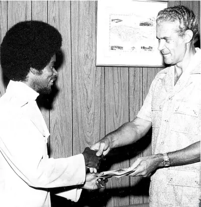  ?? GLEANER PHOTOGRAPH­ER ?? R Max Romeo (left), presenting former Prime Minister Michael Manley with a copy of his hit, ‘Socialism is Love’ at his Devon Road office. The record was a present to the then prime minister on his 50th birthday in 1974.