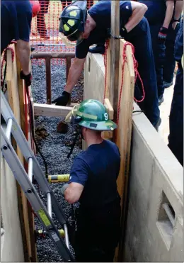  ??  ?? ABOVE: Allen Pippin (in the trench) gets help from Zack Owens (upper right) reaching into the trench during a trench rescue training exercise. Every member of the fire department will go through the training over the next two days.