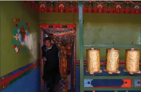  ?? REUTERS ?? Tibetan barley farmer Dzekyid walks past prayer drums in his house during an officially organised meeting in Jangdam village in Samzhubze District outside Shigatse, Tibet Autonomous Region, China, on 18 October. Picture taken during a government organised tour.