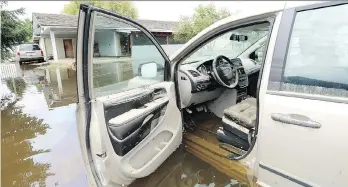  ?? JONATHAN HAYWARD/THE CANADIAN PRESS ?? A minivan is submerged in the flood waters in Grand Forks on Thursday. Water levels are expected to peak in the area by midday today.