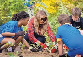  ?? ANDREW HARNIK/ASSOCIATED PRESS ?? First lady Melania Trump works in the White House Kitchen Garden on the South Lawn with members of the Boys and Girls Club of Washington on Friday.