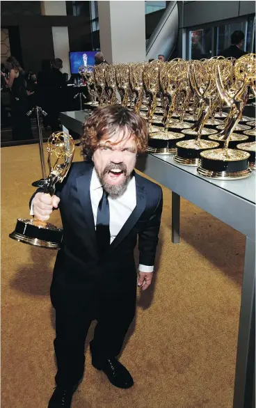  ?? — PHOTOS: THE ASSOCIATED PRESS ?? Peter Dinklage enjoys his Emmy for outstandin­g supporting actor in a drama series for Game of Thrones. The series also won for best drama.