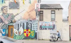  ?? ?? TROUBLING REMINDERS: A mural depicts support for a united Ireland alongside election posters in a Catholic stronghold of Belfast, Northern Ireland in April.