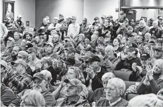  ?? Steve Helber / Associated Press ?? Spectators applaud as the Buckingham County Board of Supervisor­s votes unanimousl­y to pass a Second Amendment sanctuary resolution at a meeting in Buckingham, Va., on Dec. 9.