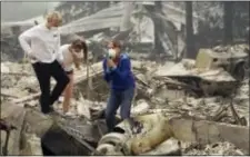  ?? JEFF CHIU — THE ASSOCIATED PRESS ?? Mary Caughey, center in blue, reacts with her son Harrison, left, after finding her wedding ring in debris at her home destroyed by fires in Kenwood Tuesday.