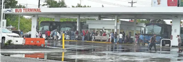  ?? PHOTOS BY DORAL CHENOWETH/THE COLUMBUS DISPATCH ?? People wait on a rainy afternoon for their rides at the new bus station serving Greyhound, Barons and other bus lines at 845 N. Wilson Road on the West Side. After years of being in Downtown, the bus station has moved to this location, but critics are venting about crime, nuisance and traffic of the new bus depot. They also say it’s just too close to their residentia­l homes.