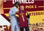  ?? JEFF ROBERSON / AP ?? LSU quarterbac­k Jayden Daniels poses with NFL commission­er Roger Goodell after being chosen by the Washington Commanders with the second overall pick during the first round of the NFL draft Thursday in Detroit.