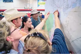  ?? EDDIE MOORE/JOURNAL ?? Sen. Ted Barela, top left, tries to answer questions for Sandra Scott, center, from Escabosa, and others about the Dog Head Fire and the danger to their homes during a public meeting at Roosevelt Middle School in Tijeras on Friday. Scott had to leave...