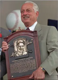  ?? THE ASSOCIATED PRESS FILE ?? Tommy Lasorda poses with his Hall of Fame plaque after his induction to the Baseball Hall of Fame in Cooperstow­n, N.Y., on Aug. 3, 1997. Lasorda, the fiery manager who guided the Los Angeles Dodgers to two World Series titles and tortured his home-area Phillies in back to back National League title series in 1977 and ‘78, died Thursday night at 93.