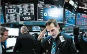  ?? SPENCER PLATT/GETTY ?? Traders work on the floor of the New York Stock Exchange on Thursday when the Dow fell more than 250 points.