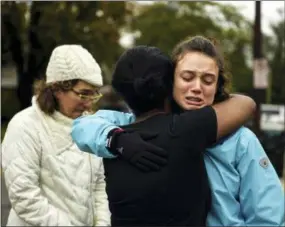  ?? ALEXANDRA WIMLEY/PITTSBURGH POST-GAZETTE VIA AP ?? From left, Kate Rothstein looks on as her daughter Simone Rothstein, right, 16, hugs a person who doesn’t want to be identified on the intersecti­on of Shady Avenue and Northumber­land Street after multiple people were shot at The Tree of Life Congregati­on synagogue Saturday in Pittsburgh.