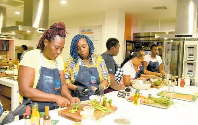  ?? FILE ?? In this 2023 photo parents are seen preparing macaroni and cheese during the launch of the the Project Star School Feeding programme at the Food and Drink Kitchen.