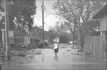  ?? SCOTT OLSON/GETTY IMAGES ?? A man walks down a flooded street in Kenner, La. following Hurricane Ida on Monday. Ida made landfall Sunday as a Category 4 storm southwest of New Orleans.