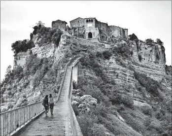  ?? DOMINIC ARIZONA BONUCCELLI/RICK STEVES’ EUROPE PHOTOS ?? A footpath is all that connects Italy’s hill town of Civita di Bagnoregio to the mainland.