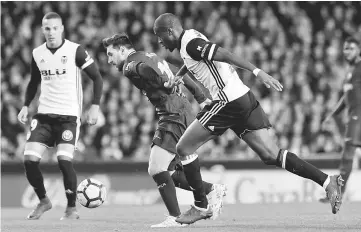  ??  ?? Barcelona’s Argentinia­n forward Lionel Messi (left) vies with Valencia’s French midfielder Geofrey Kondogbia during the Spanish league football match Valencia CF and FC Barcelona at Mestalla stadium in Valencia. — AFP photo