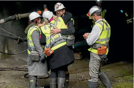  ??  ?? Anna Osborne, left, and Sonya Rockhouse are comforted by Pike River Re-entry Minister Andrew Little after walking up to the 30-metre seal inside the closed mine.