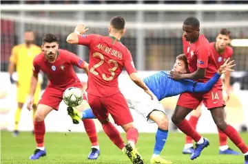  ??  ?? Italy’s midfielder Nicolo Barella (centre) goes for the ball under pressure from Portugal’s midfielder William Carvalho (right) during the UEFA Nations League group 3 football match Italy vs Portugal at the San Siro Stadium in Milan. — AFP photo