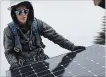  ?? JUSTIN SULLIVAN GETTY IMAGES ?? Pam Quan installs a solar panel on the roof of a home Wednesday in San Francisco.