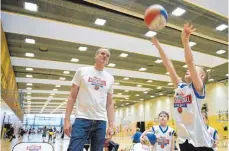  ?? FOTO: DPA ?? Der frühere Basketball-Nationalsp­ieler und heutige Jugendförd­erer Henning Harnisch beobachtet ein Kind bei einem Ballwurf.