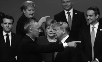  ?? AP PHOTO/FRANCISCO SECO ?? In this 2019 file photo, NATO Secretary General Jens Stoltenber­g, center front left, speaks with U.S. President Donald Trump (center front right) after a group photo at a NATO leaders meeting at The Grove hotel and resort in Watford, Hertfordsh­ire, England.